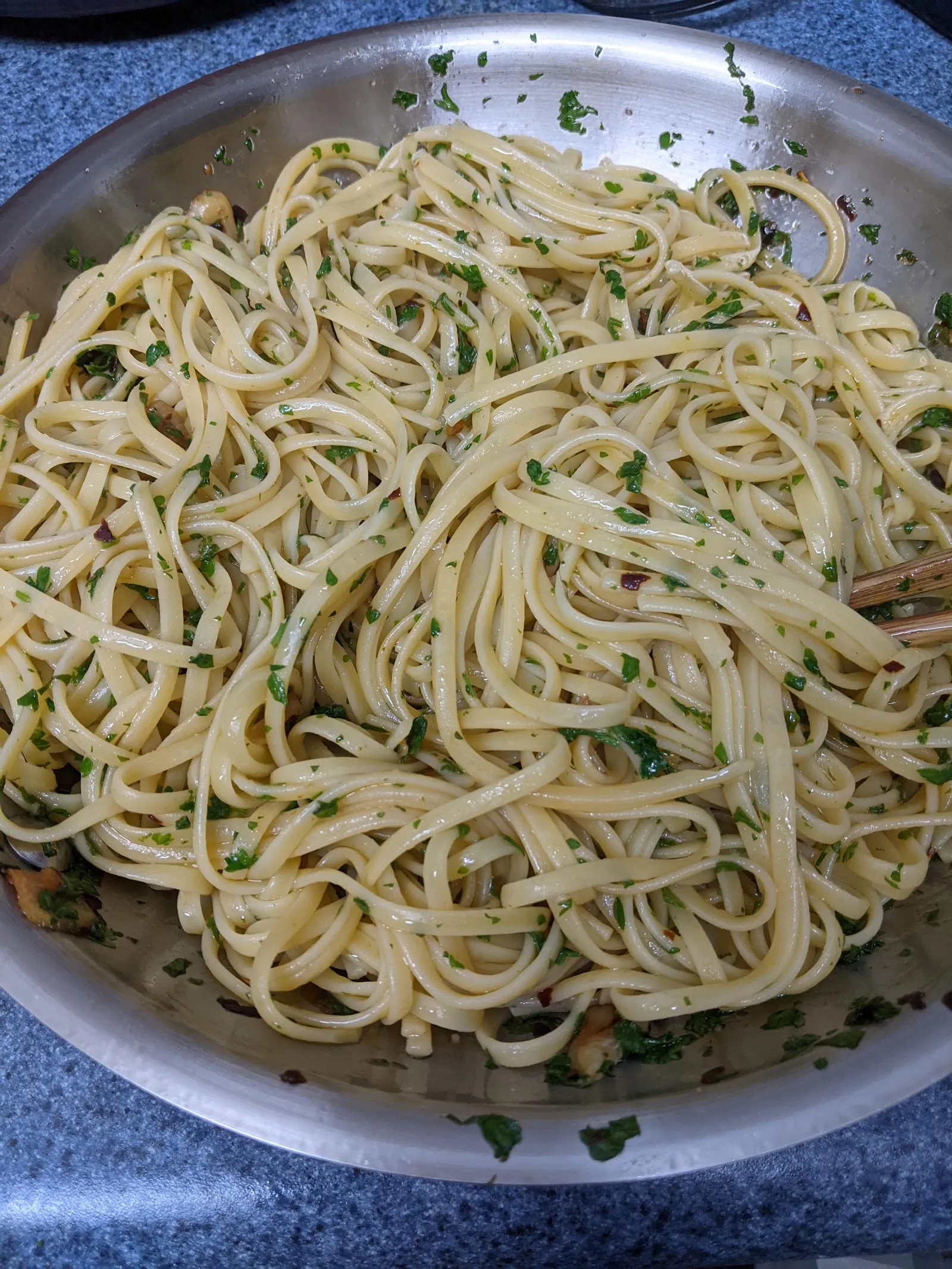 A bowl of spaghetti aglio e olio flecked with parsley