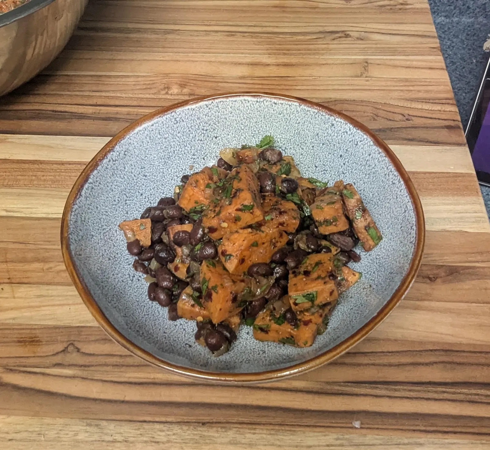 Roasted sweet potato and black bean salad in a dark bowl